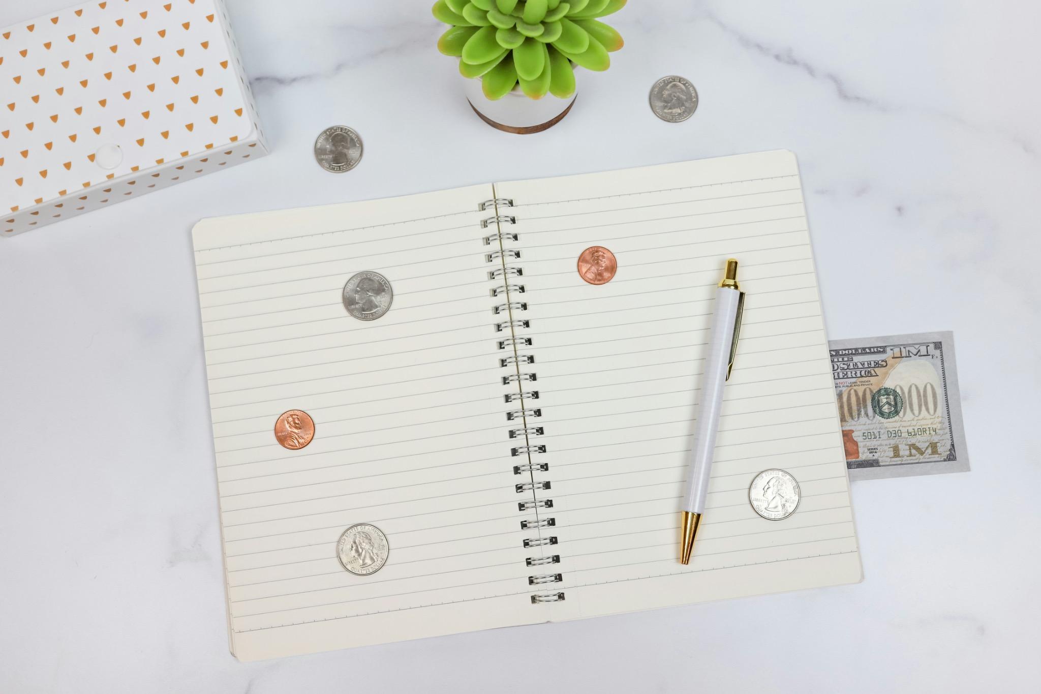 Cuaderno con monedas y billetes-planificación del ahorro.